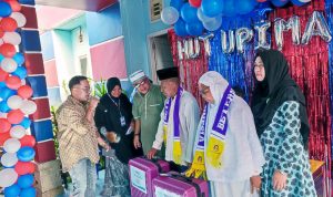 Rayakan Hari Jadi ke 7 Tahun Upi Mart bagi-bagi sembako murah dan paket umroh gratis. Tampak dua warga menerima dua paket umroh gratis.
